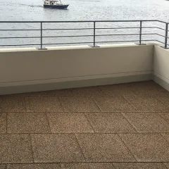 Balkon mit Blick aufs Wasser, verlegt mit WARCO Terrassenplatten Classic. Der Belag ist rutschhemmend, stoßdämpfend, pflegeleicht und frostbeständig – eine sichere und komfortable Fläche für Kinder, Senioren und Haustiere.