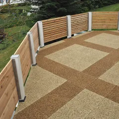 Balkon mit hellbraun dunkelbraun gemusterten Platten. Das hölzerne Geländer passt farblich zu den Balkonplatten. Der Blick fällt in den Garten mit gemähtem Rasen.